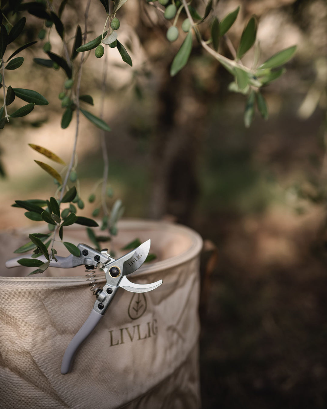 LIVLIG Gartenschere und Laubsack Beige - im Bild Schere am Laubsack angelehnt 