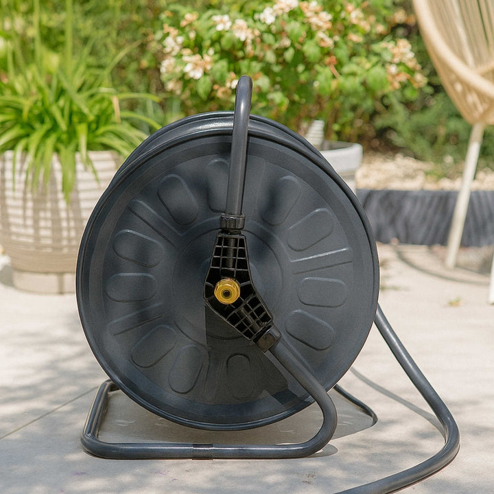 Gartenschlauch-Set mit Trommel Authentic Anthracite von LIVLIG, auf grauem Untergrund, mit goldenem Sprühkopf und dunklem Schlauch.