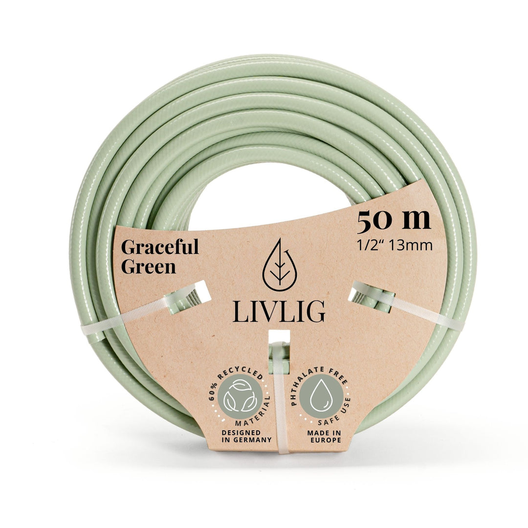 Grüner Design-Gartenschlauch Graceful Green von LIVLIG, aufgerollt und mit Papierbanderole befestigt.