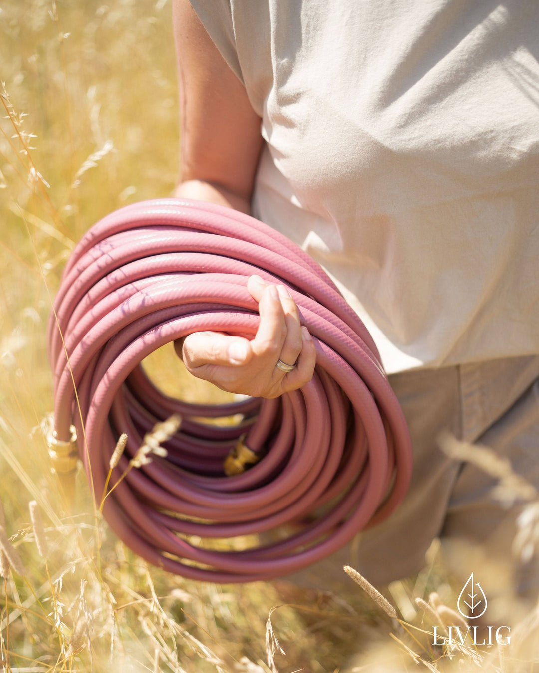 a person holding a hose in a field