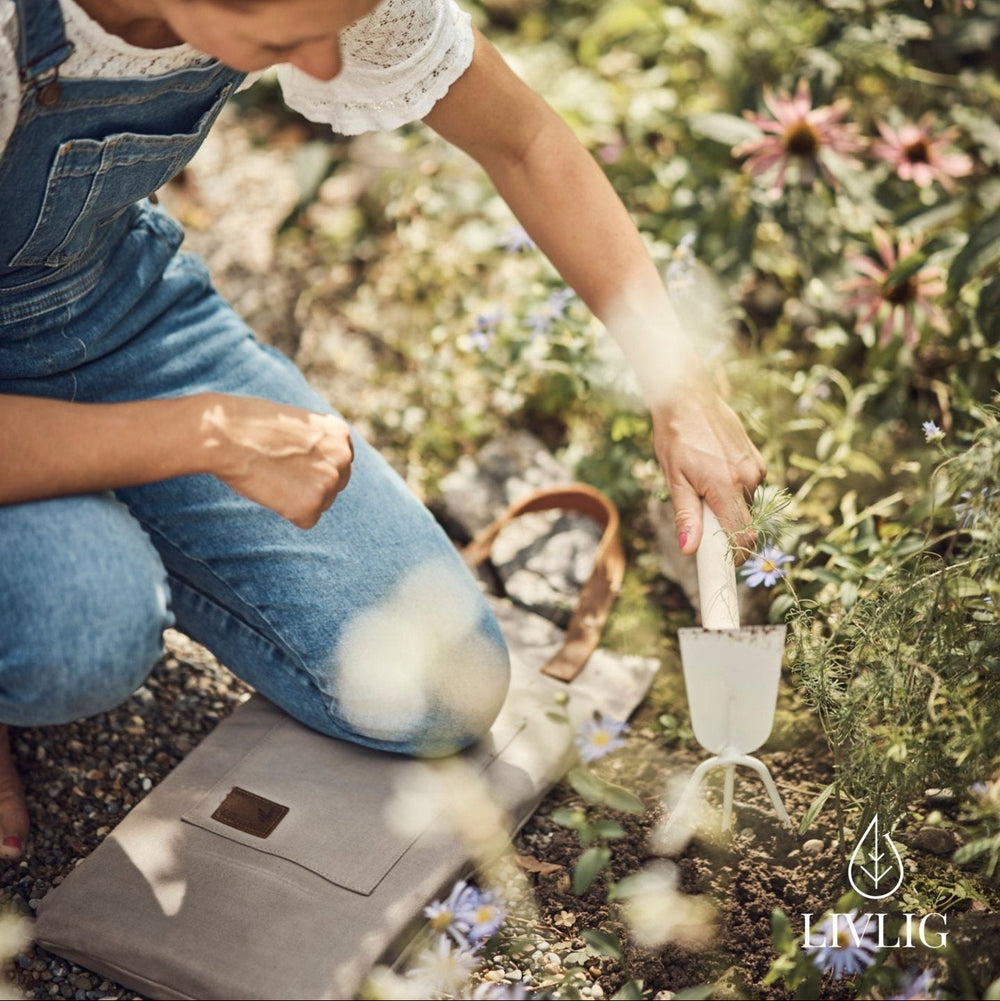 Gartenwerkzeugset von LIVLIG, das in einem Garten mit Blumen in der Erde verwendet wird.