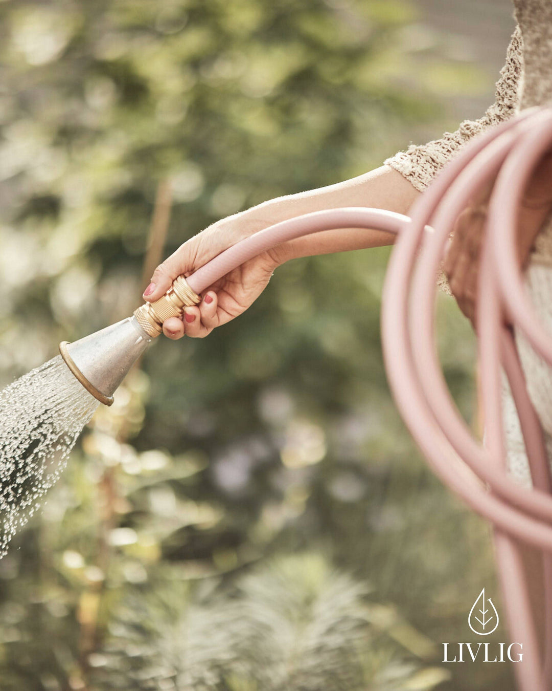 a woman is holding a hose and spraying water