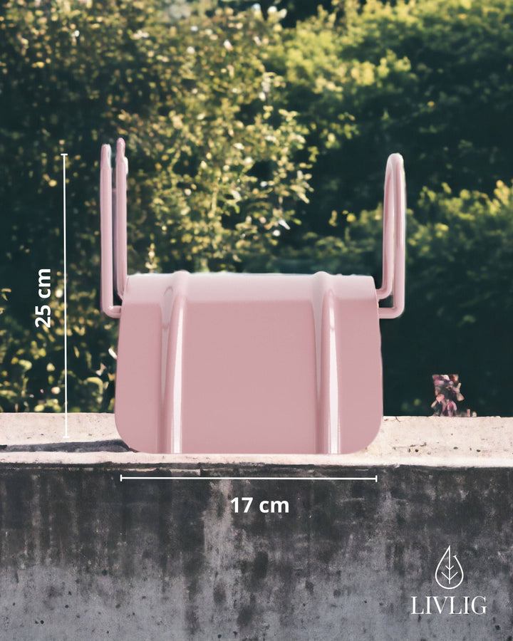 a pink object sitting on top of a cement wall