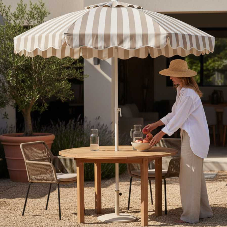 Beiger Premium Sonnenschirm 200cm von LIVLIG mit gestreiftem Muster und gewelltem Rand über einem runden Gartentisch.
