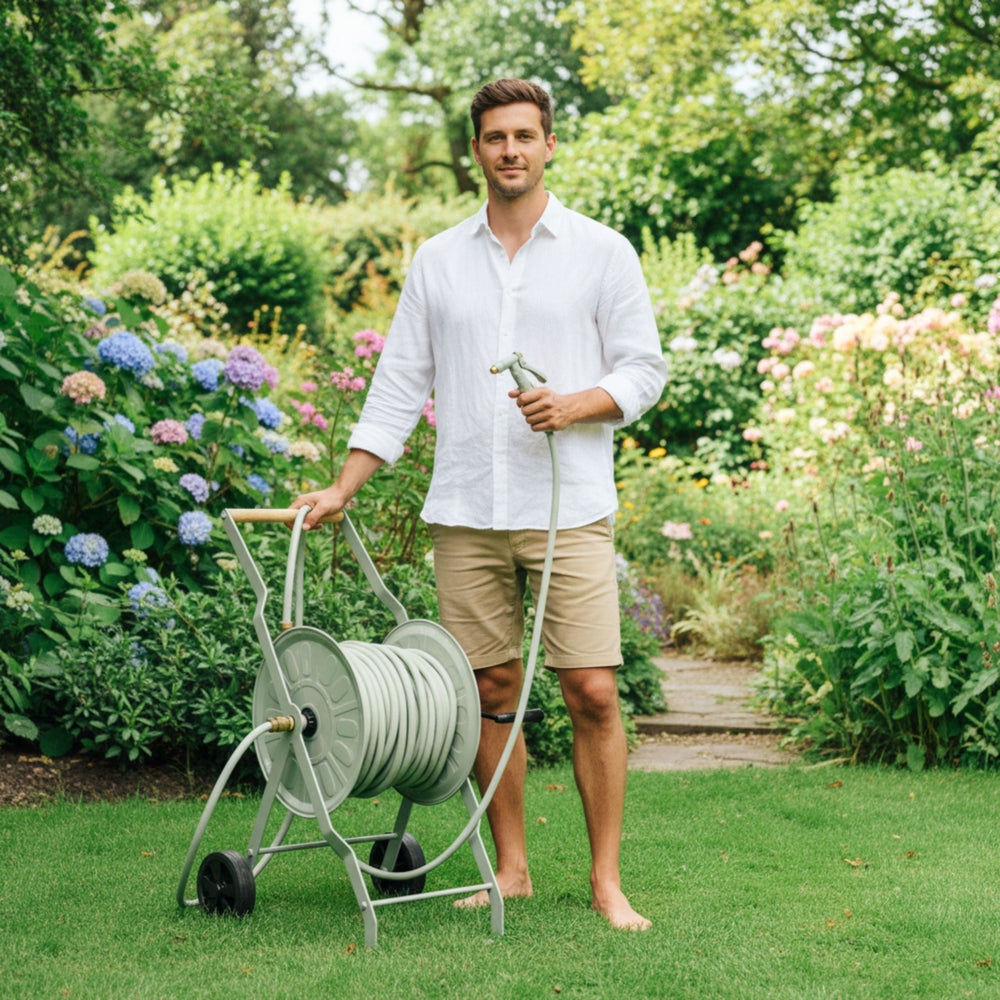 2m Gartenschlauch Anschlussgarnitur von LIVLIG, im Garten mit barfüßigem Mann mit Schlauchwagen.