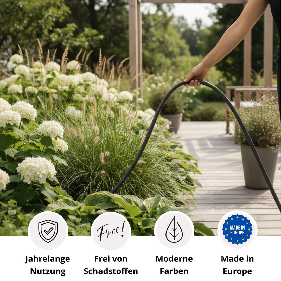 Anthrazitfarbener Design-Gartenschlauch Authentic von LIVLIG, vor Pflanzen und Holzboden im Außenbereich.
