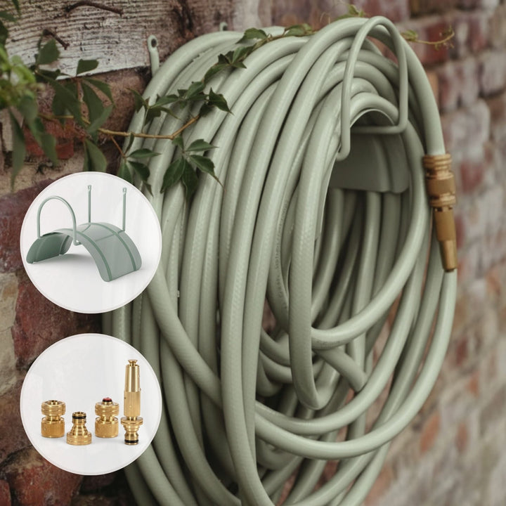 Grüner Design Gartenschlauch Homefarming von LIVLIG, aufgerollt an einer Ziegelmauer mit Efeubewuchs.