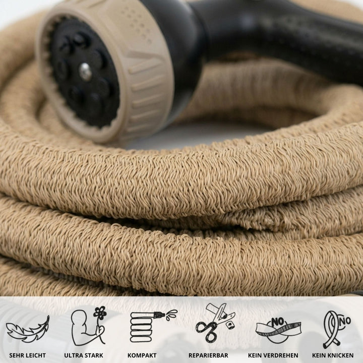 Beige flexible garden hose with woven texture and black spray nozzle, coiled close-up view