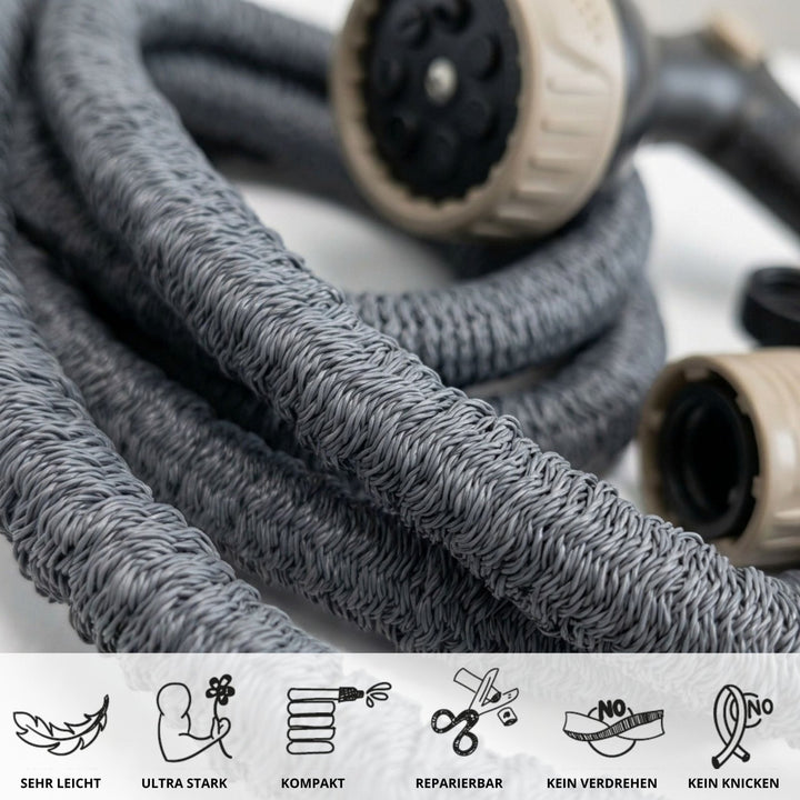 Gray flexible garden hose with braided texture and beige spray nozzle, coiled close-up view