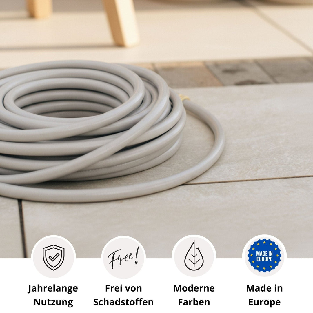 Grauer Gartenschlauch von LIVLIG, aufgerollt auf Fliesenboden, mit Logos für lange Nutzungsdauer, Schadstofffreiheit, moderne Farben und Herstellung in Europa.
