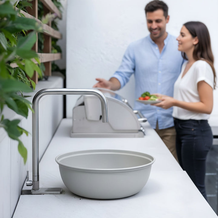 Graue Pflanzschale oder Waschschüssel von LIVLIG vor modernem Waschbecken und Paar.
