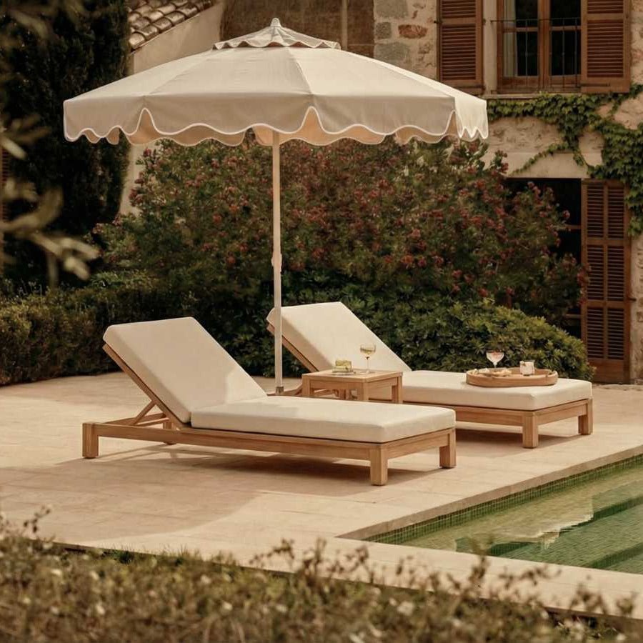 Premium Sonnenschirm 200cm von LIVLIG, beige mit gewelltem Rand, über zwei Holzliegen am Pool.
