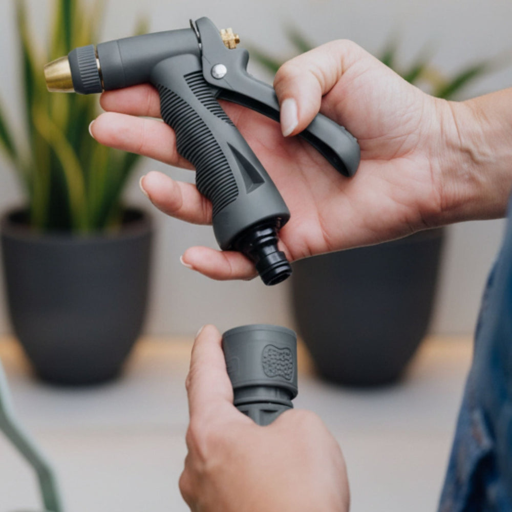 Schlauchanschluss Set aus Kunststoff von LIVLIG, mit Spritzpistole in der Hand und Anschlussstück darunter.