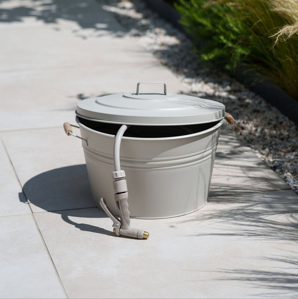 Metall Schlauchtopf von LIVLIG, mit Deckel und Schlauch auf hellen Fliesen im Freien.