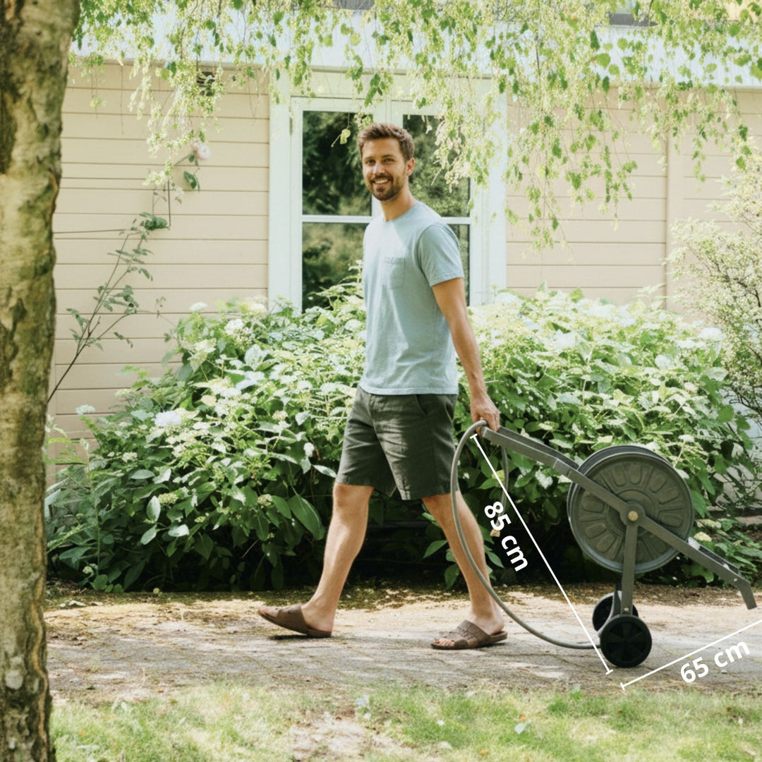 Anthrazitfarbener Gartenschlauchwagen Komplettset Authentic von LIVLIG, mit Schlauch und Rädern, im Garten mit Mann.