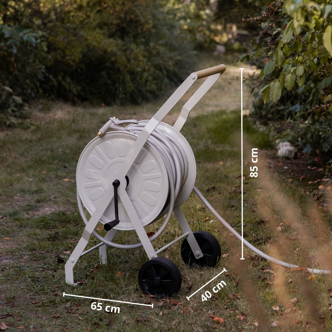 Schlauchwagen Komplettset in sanftem Grau von LIVLIG, mit schwarzem Griff und Rädern, im Garten auf Rasen.
