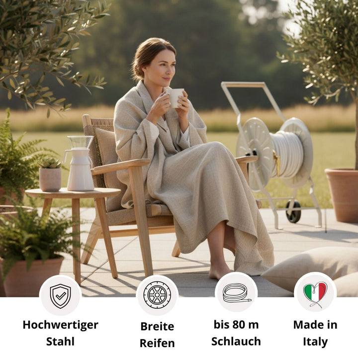 Gentle Greige Schlauchwagen Komplettset von LIVLIG, mit aufgerolltem Schlauch, auf einer Terrasse mit Topfpflanzen.